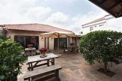 an outdoor patio with benches and an umbrella at Our Heritage Guesthouse in Kempton Park