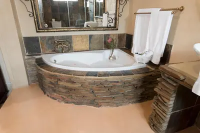 a bathroom with a bath tub made out of bricks at Our Heritage Guesthouse in Kempton Park