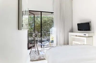 a bedroom with a bed and a large window at Alpine Attitude Boutique Hotel & Conference Venue in Pretoria