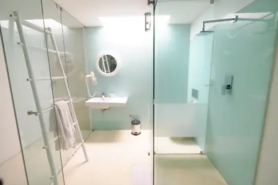 a bathroom with a glass shower and a sink at Alpine Attitude Boutique Hotel & Conference Venue in Pretoria