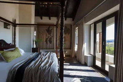a bedroom with a bed in a room with windows at Mount High Luxury Country Estate in Lydenburg