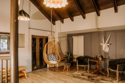 a living room with a hanging chair and a table at Mount High Luxury Country Estate in Lydenburg