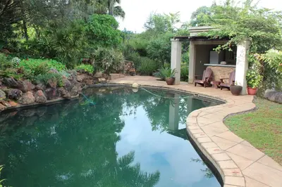 a swimming pool in a yard with a patio at Klipkopje Guest Cottage in White River