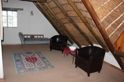 a living room with two chairs and a table at Klipkopje Guest Cottage in White River