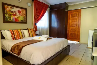 a bedroom with a large bed in a room at Hlulani Guest House in Northam