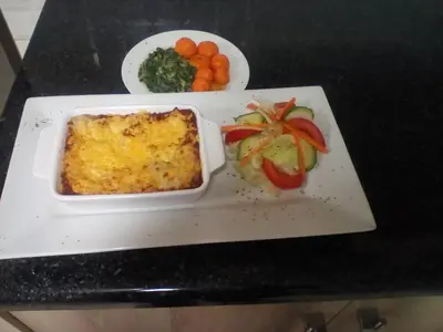 a plate with a dish of food on a table at Hlulani Guest House in Northam