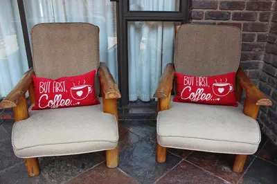 two chairs with a red pillow on top of them at Royal Game Guest House in Phalaborwa