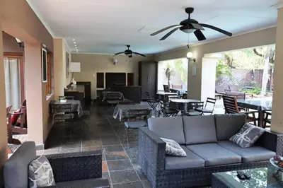 a living room with a couch and a ceiling fan at Royal Game Guest House in Phalaborwa