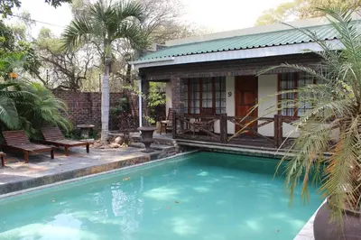 a swimming pool in front of a house at Royal Game Guest House in Phalaborwa