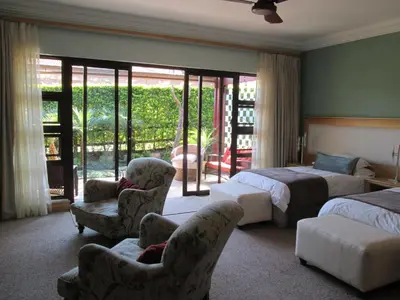 a hotel room with two beds and two chairs at Schneiders Boutique Hotel in White River