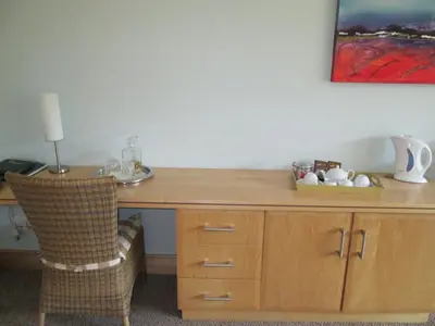 a wooden desk with a chair and a table with a lamp at Schneiders Boutique Hotel in White River