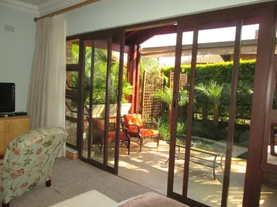 a living room with sliding glass doors to a patio at Schneiders Boutique Hotel in White River