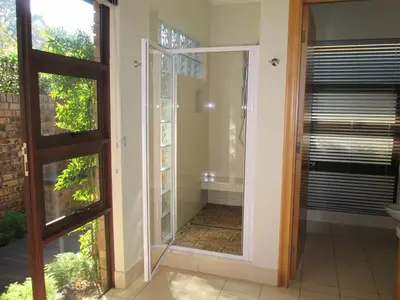 a glass door leading into a bathroom with a tub at Schneiders Boutique Hotel in White River