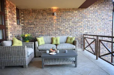 a patio with a couch and a table and a brick wall at Schneiders Boutique Hotel in White River