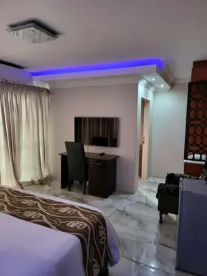 a hotel room with a bed and a desk with a computer at Zurich garden lodge benoni in Benoni