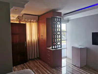 a living room with a cabinet and a window at Zurich garden lodge benoni in Benoni
