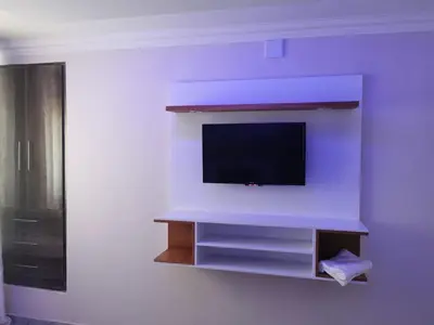 a living room with a tv on a wall at Zurich garden lodge benoni in Benoni