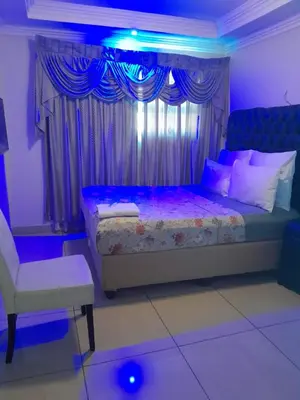 a bedroom with a bed with a purple lighting at Zurich garden lodge benoni in Benoni