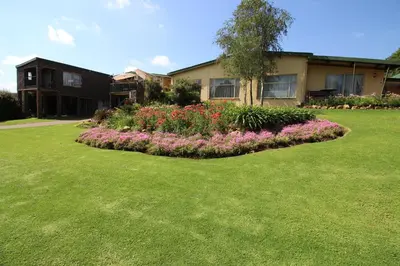 a house with a flower garden in the yard at Waterfront Guest House in Carolina