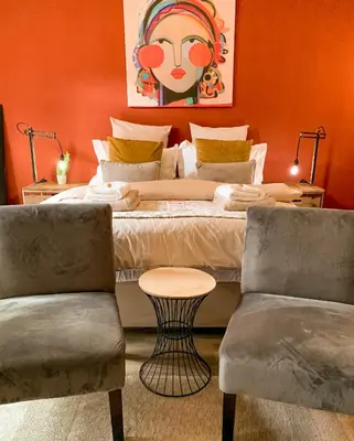 a bedroom with a bed with a table and two chairs at Lush in Graskop
