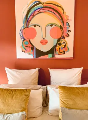 a painting of a woman on a wall above two beds at Lush in Graskop