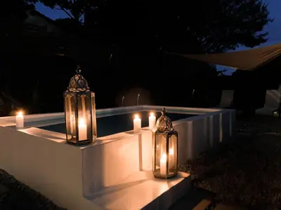 two candles are sitting on a wall with lights at Lush in Graskop