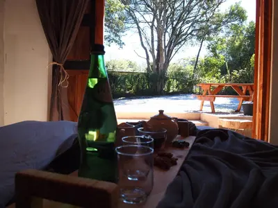 a bottle of wine sitting on a table with glasses at Lush in Graskop
