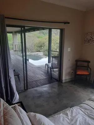 a bedroom with a sliding glass door to a deck at Hazyview Bogarts Villa in Hazyview