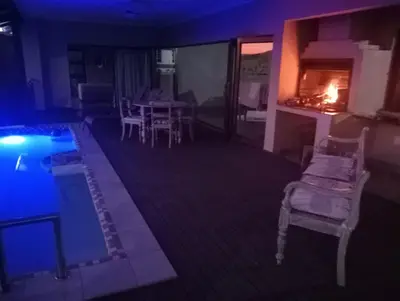 a living room with a pool and a table and chairs at Hazyview Bogarts Villa in Hazyview