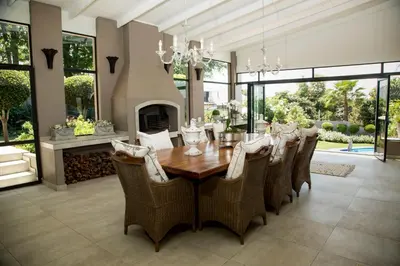 a dining room with a table and chairs and a fireplace at La Vida Luka - Luxury Guesthouse in Pretoria