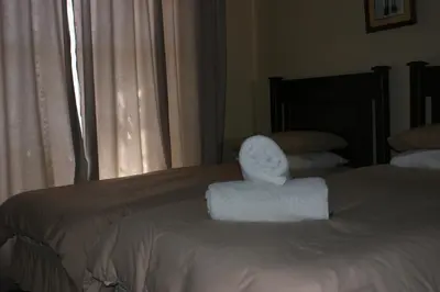a pair of towels sitting on top of a bed at Eric's Apartments in Centurion