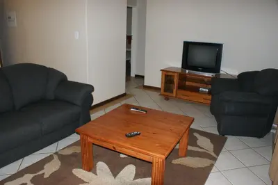 a living room with two couches and a coffee table at Eric's Apartments in Centurion