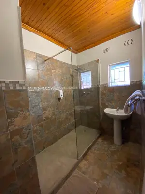 a bathroom with a shower and a sink at Magoebaskloof Mountain Lodge in Magoebaskloof