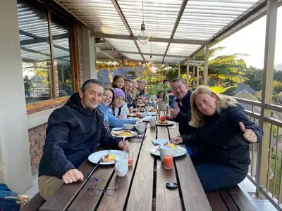 a group of people sitting at a table eating food at Magoebaskloof Mountain Lodge in Magoebaskloof