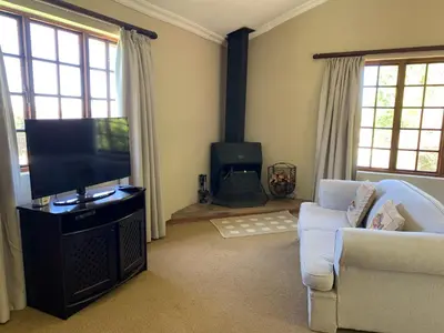 a living room with a television and a couch at Auldstone House in Dullstroom