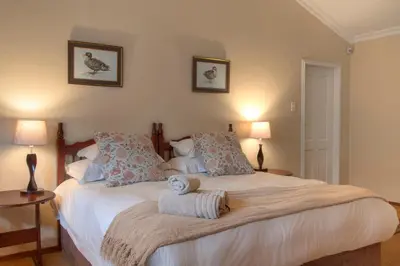 a bedroom with a bed with two towels on it at Auldstone House in Dullstroom