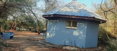 a blue building with a window and a bench at Copacopa Lodge and Conference Centre in Punda Maria