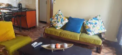 a living room with a couch with pillows and a table at Copacopa Lodge and Conference Centre in Punda Maria