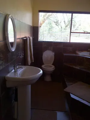 a bathroom with a sink and a toilet and a window at Copacopa Lodge and Conference Centre in Punda Maria