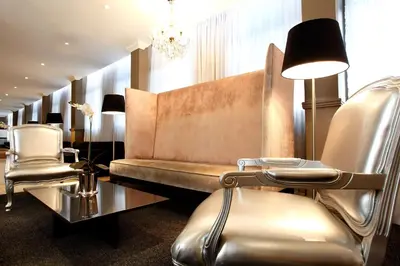a salon with chairs and a couch and a chandelier at Manhattan Hotel in Pretoria