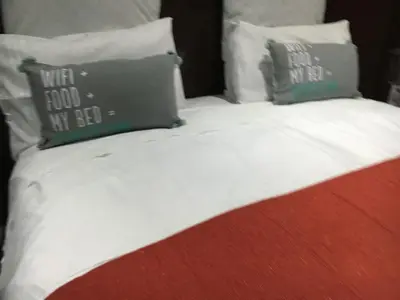 a bed with two pillows on top of it at Tassili Lodge in Kempton Park