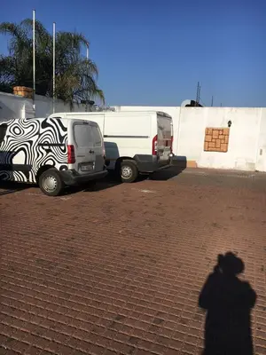 a shadow of a man standing next to a white van at Tassili Lodge in Kempton Park