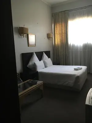 a hotel room with a bed and a window at Tassili Lodge in Kempton Park