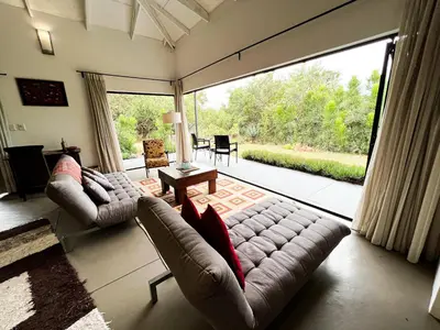 a living room with two couches and a large window at Ukuthula Hideaway in Kampersrus AH