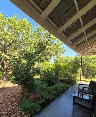 a porch with a table and chairs under a roof at Ukuthula Hideaway in Kampersrus AH