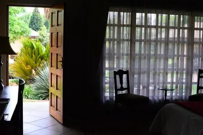 a bedroom with a door open to a room with a window at Avant Garde Lodge in Kempton Park