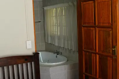 a bathroom with a bath tub and a window at Avant Garde Lodge in Kempton Park