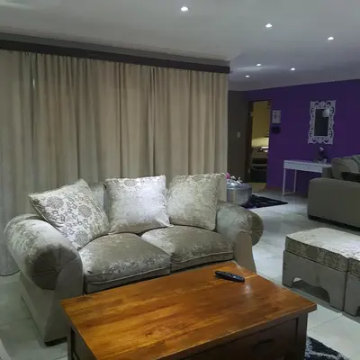 a living room with a couch and a coffee table at Dinaledi House in Bela-Bela