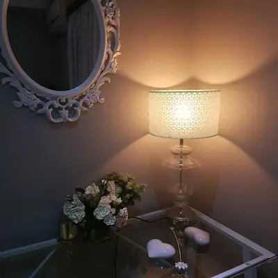 a lamp on a glass table with a mirror and flowers at Dinaledi House in Bela-Bela