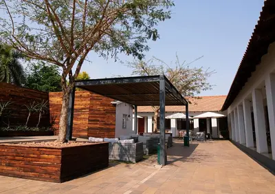a pavilion with a tree next to a building at The Doors Inn in Mokopane